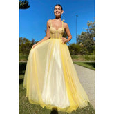 Robe de bal longue en tulle jaune à bretelles spaghetti et décolleté en cœur