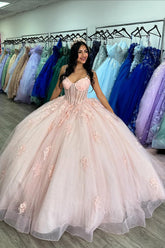 Robe de princesse rose à fines bretelles en tulle ornée d'appliqués et d'un nœud, idéale pour une quinceañera.