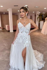 Robe de mariée trapèze longue sans manches à fines bretelles spaghetti, décolleté en V fendue sur le devant et ornée d'appliqués