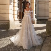 Robe de mariée élégante beige à épaules dénudées, manches longues, décolleté cœur, en tulle appliqué de sequins, coupe trapèze, pour femme.