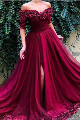 Robe longue bordeaux en tulle à épaules dénudées, manches mi-longues et coupe trapèze, avec pompons.