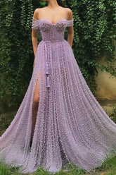 Robe de bal longue en tulle lavande, ornée de perles, à fines bretelles et fente.