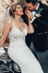 Robe de mariée sirène longue jusqu'au sol, décolleté cœur, appliques, bretelles spaghetti, sans manches et dentelle.