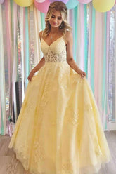 Robe de bal longue en tulle jaune, coupe trapèze, col en V, ornée d'appliques en dentelle.