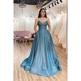 Vestido largo de fiesta de tul brillante con tirantes finos, corte en A y bolsillos.