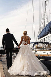 Magnifique robe de mariée longue trapèze en dentelle et tulle avec traîne chapelle et appliques.