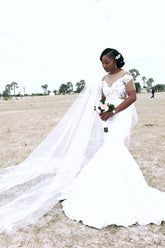 Vestido de novia sirena con apliques de tul transparente y pliegues.