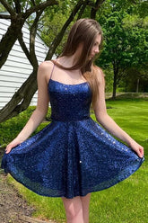 Robe courte de bal bleu marine à sequins, coupe trapèze, dos nu et bretelles croisées.