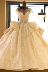 Elegante vestido de novia princesa de corte princesa con escote ilusión, mangas casquillo, apliques de tul y corte en A