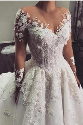 Elegante vestido de novia largo de corte A con escote barco, apliques de encaje y mangas.