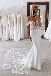 Elegantes vestidos de novia largos de corte sirena con hombros descubiertos y encaje.