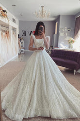 Fabuloso vestido de novia blanco de corte A, encaje, hombros descubiertos, manga larga y volantes.