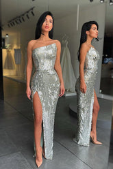 Robe de bal argentée à sequins, décolleté asymétrique et fente haute, encolure argentée tendance.