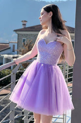 Vestido corto morado de corte línea con escote corazón y pedrería para baile de bienvenida.