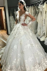 Precioso vestido de novia largo estilo princesa con escote barco, apliques de encaje, espalda descubierta, volantes y mangas.