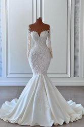 Precioso vestido de novia blanco de sirena con mangas largas y escote corazón.