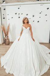 Vestido de novia largo de satén con escote corazón, volantes y mangas, estilo princesa.