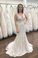 Vestido de novia de sirena con escote en V largo, tirantes anchos, encaje y espalda descubierta