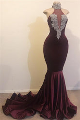 Vestido de fiesta plateado estilo sirena, con espalda descubierta, cuello alto y apliques de cuentas.
