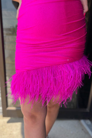 Robe de bal courte rose fuchsia à bretelles spaghetti et plumes, coupe fourreau, ornée de plumes.