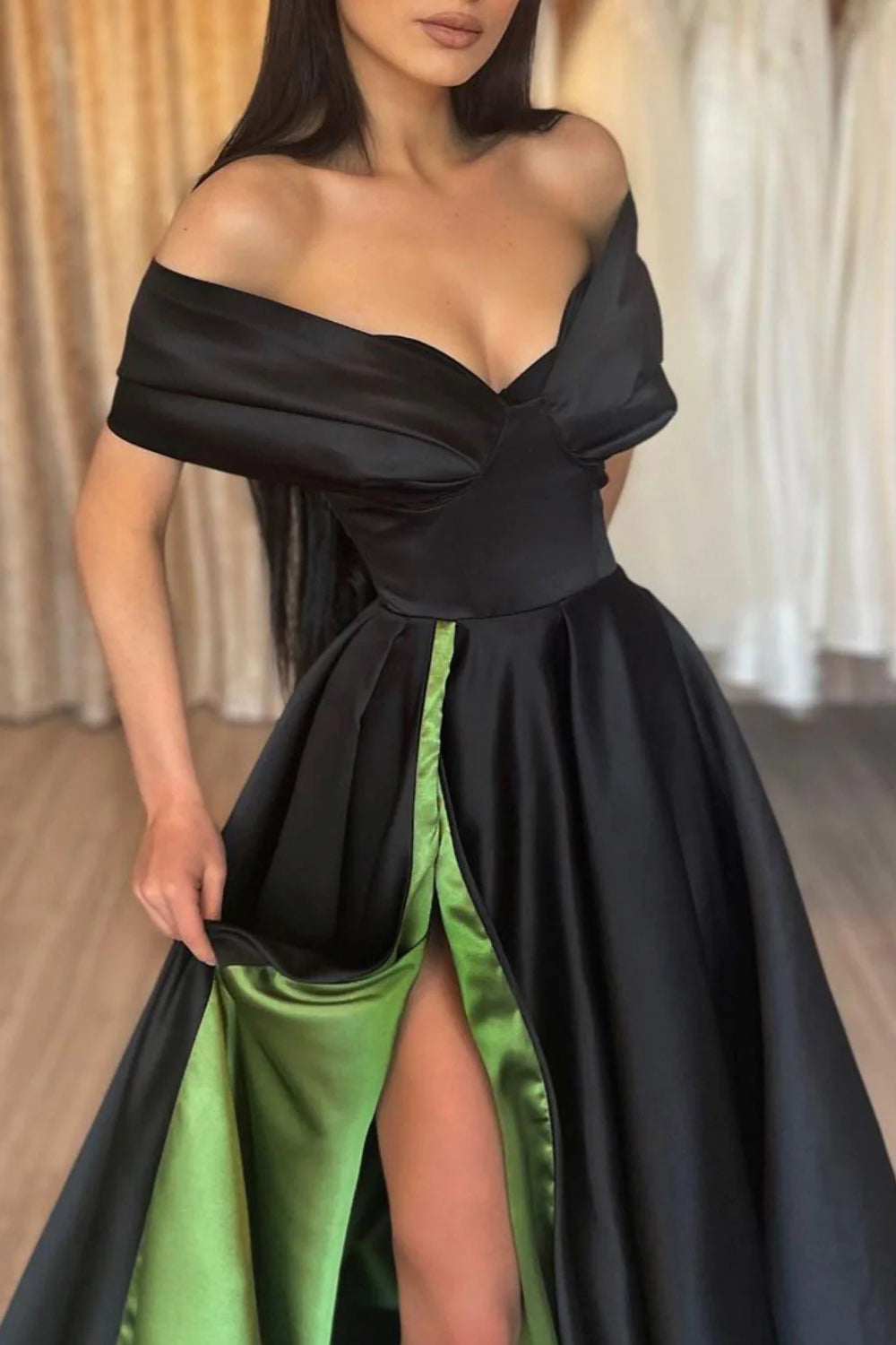 Vestido largo de fiesta negro y verde con escote barco y abertura frontal.