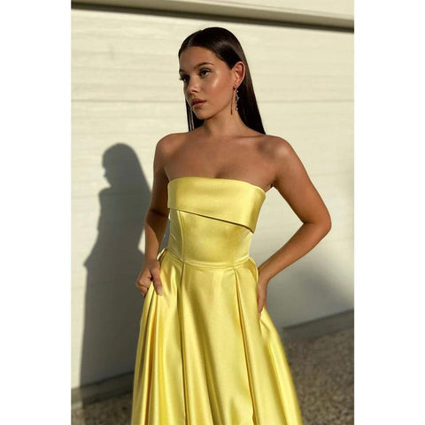Vestido largo de fiesta amarillo satinado sin tirantes con abertura alta y bolsillos 