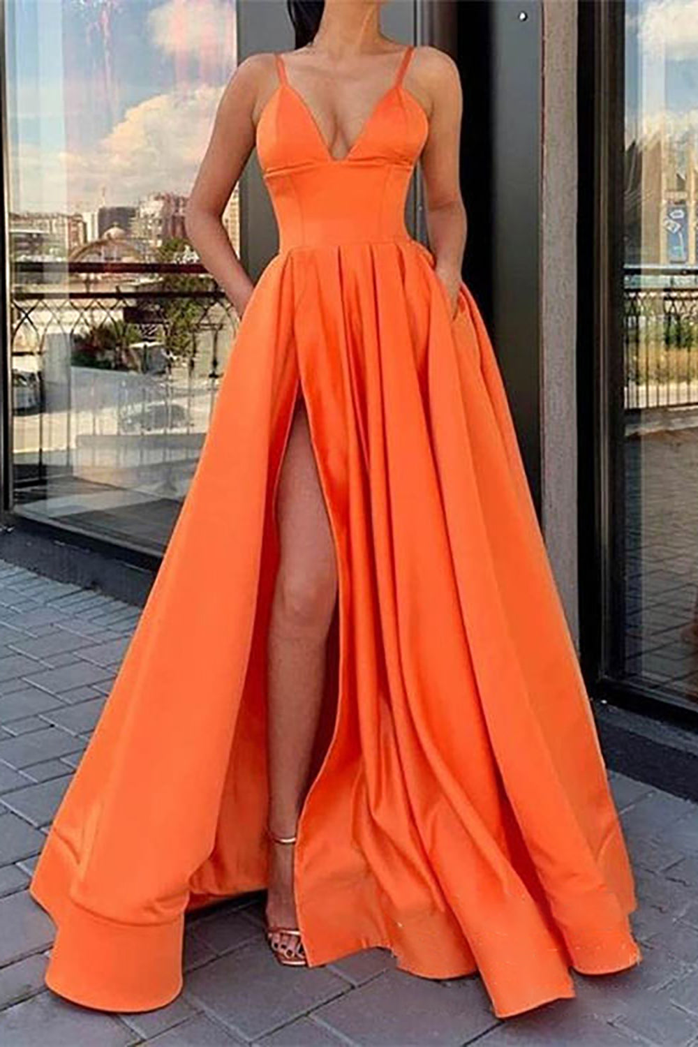 Vestido largo de fiesta negro de corte A con tirantes finos y falda asimétrica.