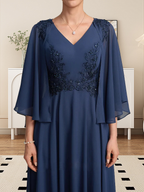 Vestido de corte A, escote en V, largo hasta la rodilla, de gasa, encaje, con lentejuelas y pedrería para la madre de la novia.