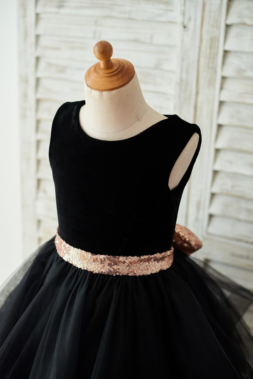Vestido negro de terciopelo con lazo de lentejuelas en forma de corazón en la espalda y largo hasta la rodilla 