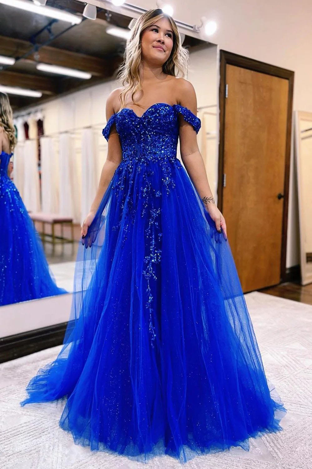 Vestido largo de fiesta azul marino con escote barco y abertura frontal.