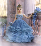 Vestido de niña de las flores de tul azul con tirantes finos y aplicaciones.