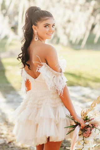 Robe de bal courte trapèze en tulle à épaules dénudées et à volants, ornée de plumes.