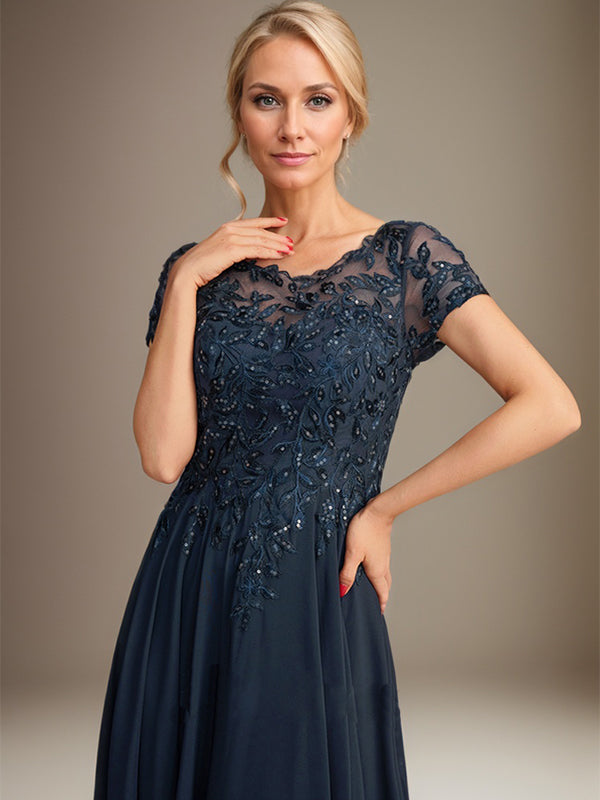 Robe de mariée longue en mousseline de soie, coupe trapèze, décolleté rond, ornée d'appliqués et de sequins, idéale pour la mère de la mariée. 