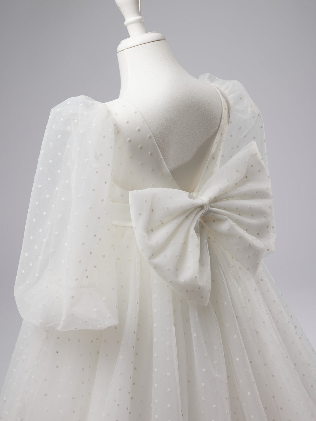 Elegante vestido de niña de las flores para la Primera Comunión, de tul con lunares, mangas abullonadas y cola corta. 