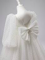 Elegante vestido de niña de las flores para la Primera Comunión, de tul con lunares, mangas abullonadas y cola corta. 