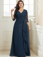Vestido de novia de corte línea A, cuello en V, largo hasta el suelo, de encaje y gasa, con lentejuelas y volantes en cascada. 