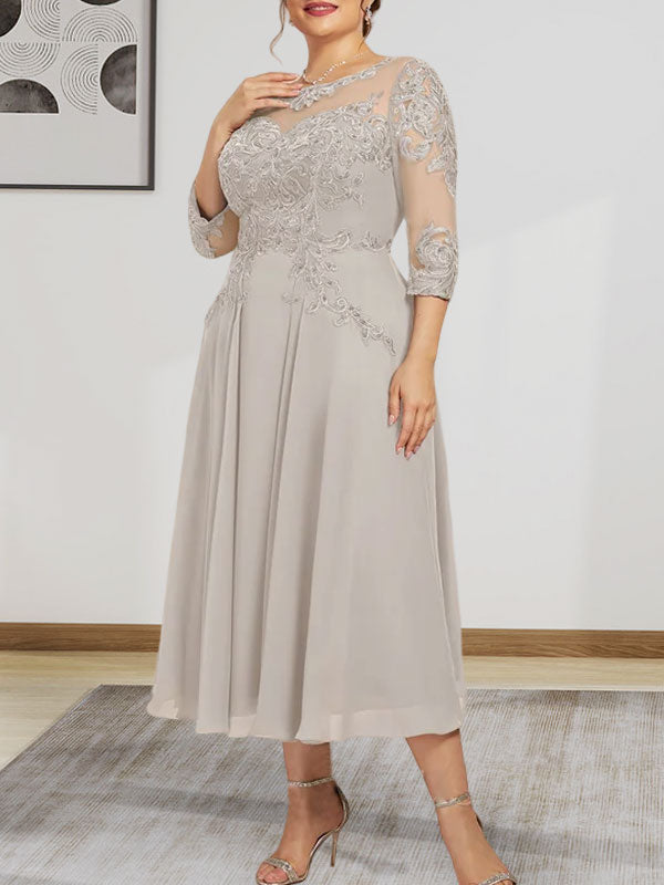 Robe de mariée trapèze en mousseline de soie et dentelle, longueur thé, ornée de perles et de sequins, avec décolleté en A et effet illusion.