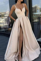Vestido largo de fiesta negro de corte A con tirantes finos y falda asimétrica.