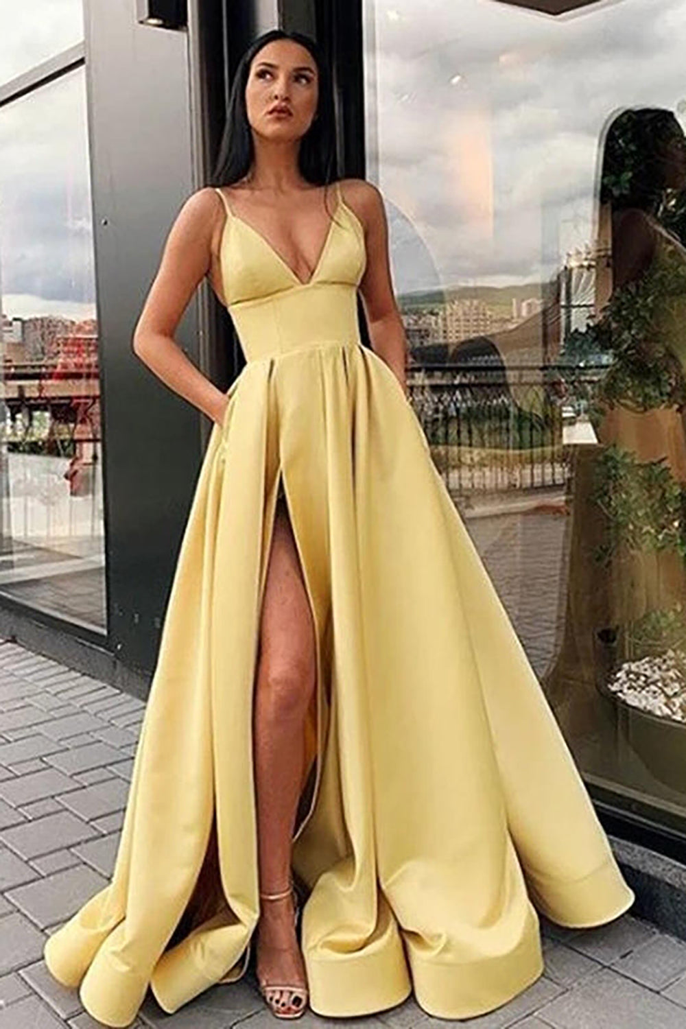 Vestido largo de fiesta negro de corte A con tirantes finos y falda asimétrica.