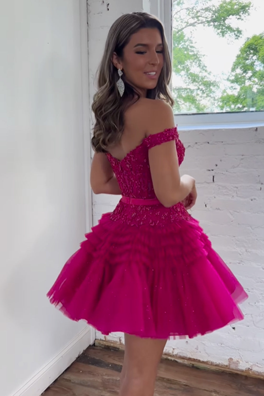 Vestido corto de princesa color fucsia con hombros descubiertos y volantes para fiesta de bienvenida