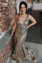Robe de bal longue sirène à sequins champagne, décolleté plongeant en V et traîne.