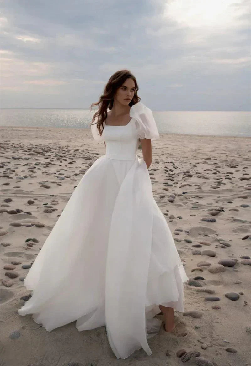 Robe de mariée charmante, coupe trapèze, col carré, manches courtes et traîne