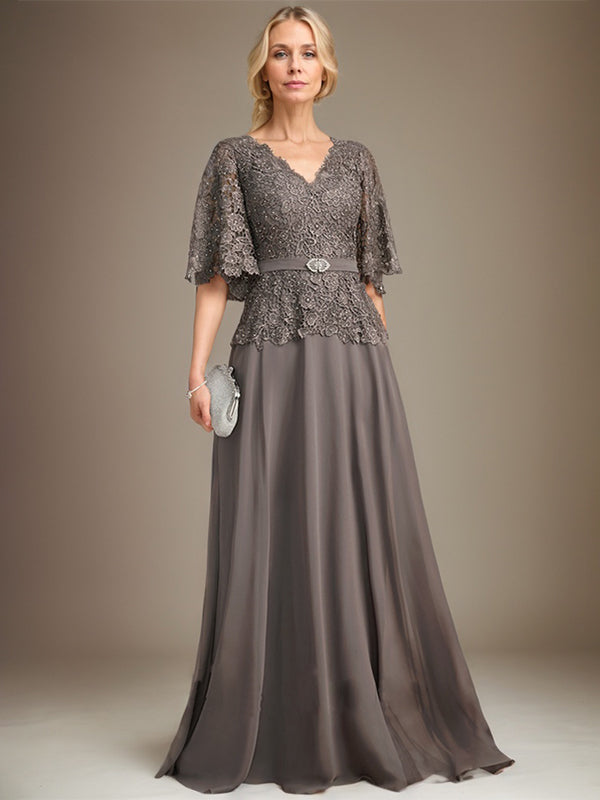 Vestido de novia de corte A, escote en V, largo hasta el suelo, de gasa y encaje, con broche de cristal y pedrería. 