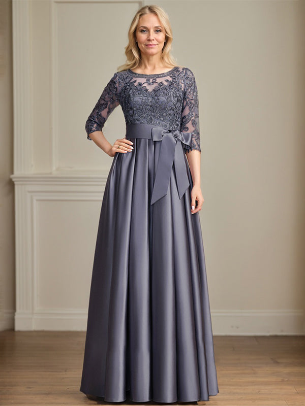 Vestido de novia corte A, escote ilusión, largo hasta el suelo, de satén y encaje, con lazo de lentejuelas. 