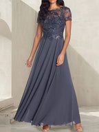 Vestido largo de corte A, color gris carbón, con escote redondo y detalles de pedrería, ideal para la madre de la novia.