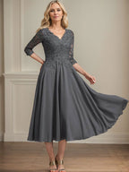 Vestido de corte A, escote en V, largo hasta la rodilla, de gasa, encaje, con lentejuelas y pedrería para la madre de la novia. 