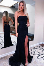 Vestido largo de fiesta negro de lentejuelas, sin tirantes y corte sirena, con abertura frontal.