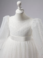 Elegante vestido de niña de las flores para la Primera Comunión, de tul con lunares, mangas abullonadas y cola corta. 