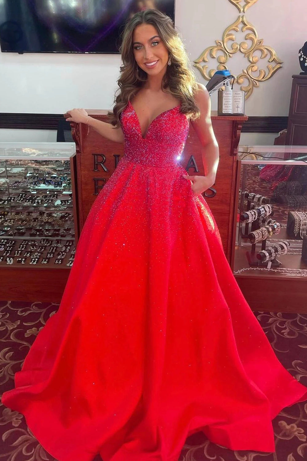 Vestido largo rojo de fiesta con tirantes finos, corte en A y detalles de pedrería.