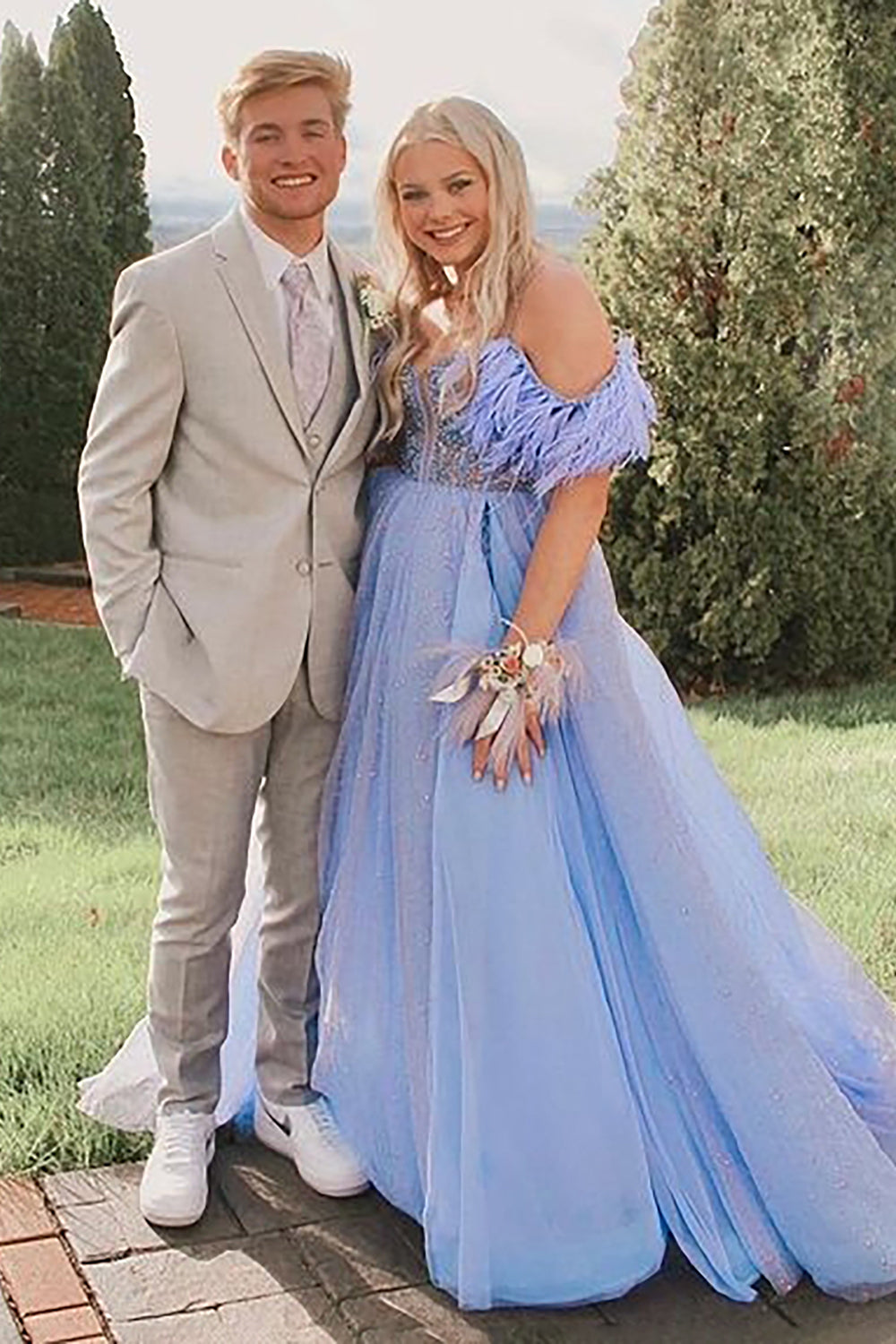 Vestido largo de fiesta azul con escote barco y plumas
